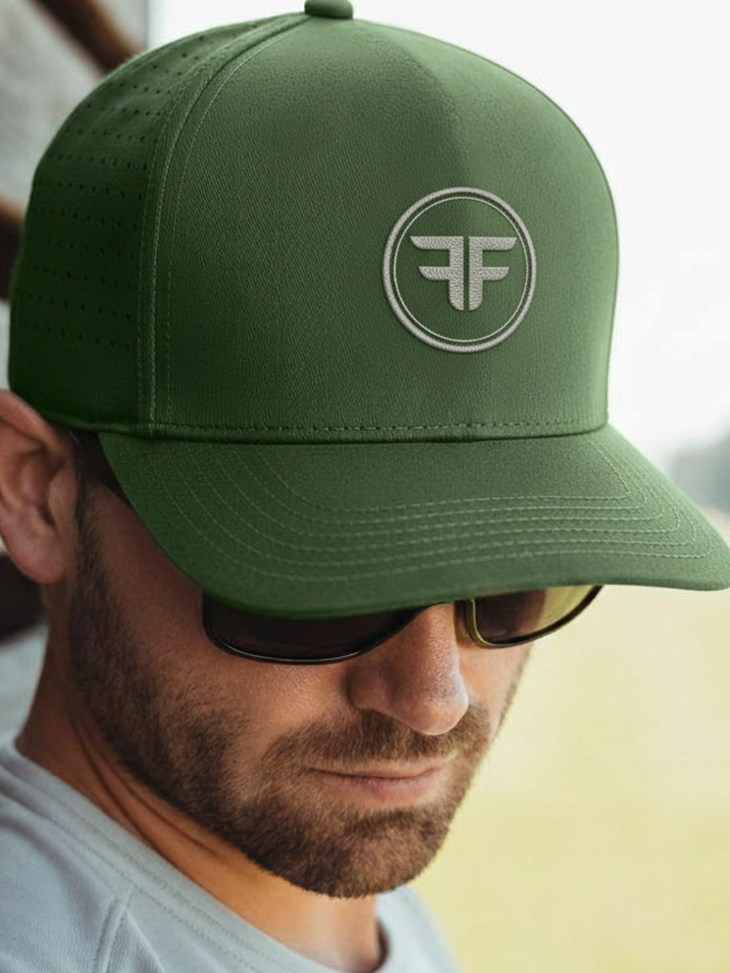 Man wearing a green cap with a logo, looking away from the camera.